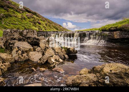 This is the stream above Hull Pot in Ribblesdale in the Yorkshire Dales National Park. Here it flows over a rock shelf creating a mini waterfall. Stock Photo