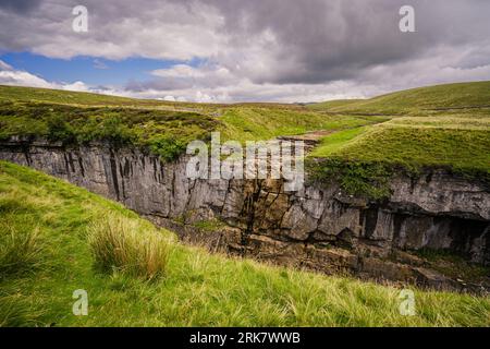 Walkers on the Yorkshire Three Peaks often make a small detour to visit Hull Pot a collapsed cavern and very large hole in the ground. Stock Photo