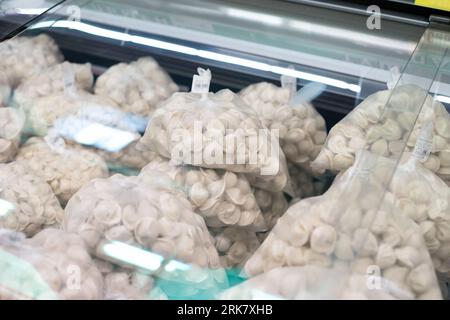 frozen uncooked dumplings in transparent bag a lot in store refrigerator Stockfoto