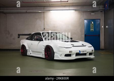 Detail einer weißen Nissan Silvia S13 mit Spoiler und Karosseriesatz in einer Tiefgarage Stockfoto