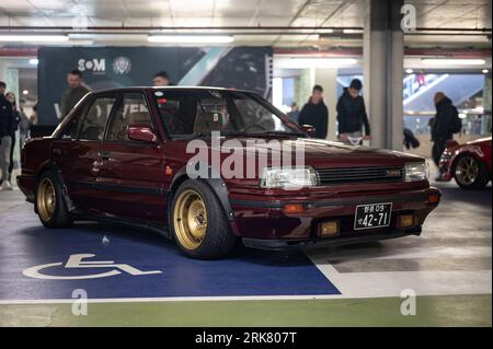 Klassischer Nissan Bluebird der T12 T72 Serie in tiefem kastanienbraunen Rot, abgestimmt auf Straßenrennen Stockfoto