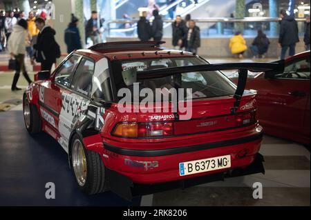 Rear view of an old tuned red Mazda 323f BG 1989 with spoiler and widening kit Stock Photo