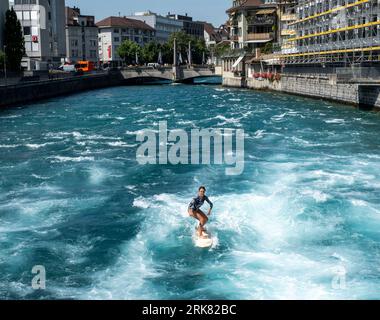 Eine Surferin kühlt sich auf der Aare in Thun, Schweiz, während einer Hitzewelle ab, bei der die Temperaturen heute, Donnerstag, den 24. August, 36 °C erreicht haben. Credit: Ian Rutherford/Alamy Live News. Stockfoto