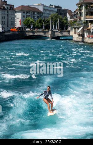 Eine Surferin kühlt sich auf der Aare in Thun, Schweiz, während einer Hitzewelle ab, bei der die Temperaturen heute, Donnerstag, den 24. August, 36 °C erreicht haben. Credit: Ian Rutherford/Alamy Live News. Stockfoto