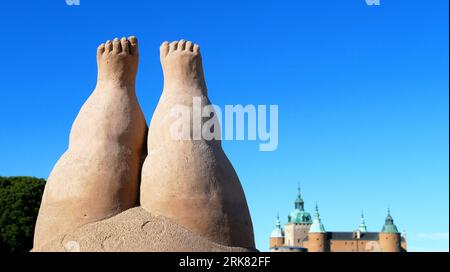 Eine Skulptur aus zwei menschlichen Füßen aus der Nähe vor einem Hintergrund moderner Stadtgebäude Stockfoto