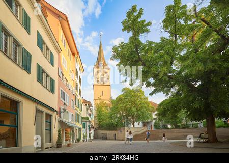 A diverse group of people walk in the city streets in the vicinity of St Peter's Church in Zurich, Switzerland Stockfoto
