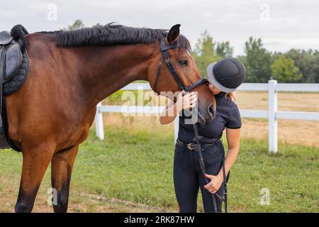 Weibliche Reiterhand streichelt sanft die wunderschöne dicke rote Pferdemäne, Nahaufnahme. Equitation und Tierliebhaber-Konzept. Stockfoto