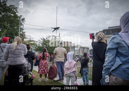 London, Großbritannien. August 2023. Die international bekannte Seilwandererin Tatiana Mosio Bongonga überquert den General Gordon Square in Woolwich und eröffnet das Greenwich+Docklands International Festival 2023. Das atemberaubende Spektakel von Open Lines feiert den Akt des furchtlosen Optimismus mit der Bedeutung des kollektiven Bemühens, Zusammengehörigkeit und Hoffnung zu schaffen. Guy Corbishley/Alamy Live News Stockfoto