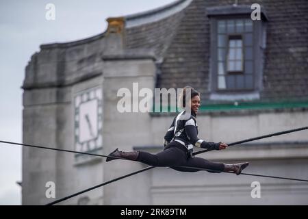 London, Großbritannien. August 2023. Die international bekannte Seilwandererin Tatiana Mosio Bongonga überquert den General Gordon Square in Woolwich und eröffnet das Greenwich+Docklands International Festival 2023. Das atemberaubende Spektakel von Open Lines feiert den Akt des furchtlosen Optimismus mit der Bedeutung des kollektiven Bemühens, Zusammengehörigkeit und Hoffnung zu schaffen. Guy Corbishley/Alamy Live News Stockfoto