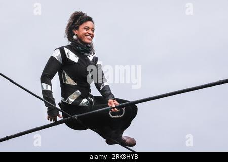 London, Großbritannien. August 2023. Die international bekannte Seilspringerin Tatiana Mosio Bongonga auf dem Hochseil für die Probeaufführung ihrer Show „Open Lines“. Mit Hilfe von zwölf außergewöhnlichen Menschen aus der örtlichen Gemeinde macht sie eine erstaunliche Überfahrt und eröffnet morgen offiziell das GDIF 2023 (Greenwich and Docklands International Festival). Bei der Veranstaltung, die nur eine Nacht lang stattfindet, am morgigen Abend wird die Bedeutung von kollektivem miteinander und Hoffnung gefeiert. Quelle: Imageplotter/Alamy Live News Stockfoto