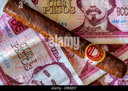 Cuba. Cuban pesos money and cigar. Associations with Cuba. Holidays on the beautiful island of Cuba. Stock Photo