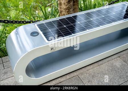 Close-up view of a public bench in the park with solar panel installed on it Stock Photo