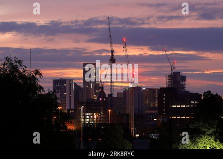 Sonnenaufgang im Stadtzentrum von Leeds mit Turmdrehkranen, die an verschiedenen Entwicklungen arbeiten Stockfoto