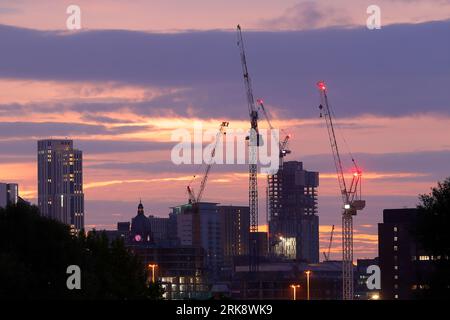 Sonnenaufgang im Stadtzentrum von Leeds mit Turmdrehkranen, die an verschiedenen Entwicklungen arbeiten Stockfoto