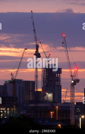 Sonnenaufgang im Stadtzentrum von Leeds mit Turmdrehkranen, die an verschiedenen Entwicklungen arbeiten Stockfoto