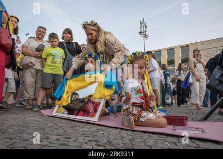 Am 24. August 2023 versammelten sich Ukrainer am Brandenburger Tor in Berlin, um den Unabhängigkeitstag der Ukraine zu begehen. Aber das war keine gewöhnliche Feier. Die Menge, ein Meer von Sonnenblumen, Fahnen, Fahnen und traditioneller ukrainischer Kleidung, kam mit einer Botschaft der Erinnerung und Belastbarkeit. In einer symbolischen Geste hielten die Teilnehmer Spiegel hoch, insgesamt 503, die jeweils das Gesicht eines Kindes widerspiegeln, das im russischen Krieg gegen die Ukraine verloren ging. Die Spiegel funkelten unter der untergehenden Sonne und dienten als eindringliche Erinnerung an die 503 ukrainischen Kinder, deren Leben in dem Konflikt abrupt und rücksichtslos genommen wurde. "Ukrainisch Stockfoto