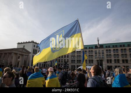 Berlin, Deutschland. August 2023. Am 24. August 2023 versammelten sich Ukrainer am Brandenburger Tor in Berlin, um den Unabhängigkeitstag der Ukraine zu begehen. Aber das war keine gewöhnliche Feier. Die Menge, ein Meer von Sonnenblumen, Fahnen, Fahnen und traditioneller ukrainischer Kleidung, kam mit einer Botschaft der Erinnerung und Belastbarkeit. In einer symbolischen Geste hielten die Teilnehmer Spiegel hoch, insgesamt 503, die jeweils das Gesicht eines Kindes widerspiegeln, das im russischen Krieg gegen die Ukraine verloren ging. Die Spiegel funkelten unter der untergehenden Sonne und dienten als eindringliche Erinnerung an die 503 ukrainischen Kinder, deren Leben abrupt und rücksichtslos war Stockfoto