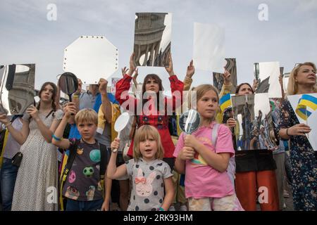 Berlin, Deutschland. August 2023. Am 24. August 2023 versammelten sich Ukrainer am Brandenburger Tor in Berlin, um den Unabhängigkeitstag der Ukraine zu begehen. Aber das war keine gewöhnliche Feier. Die Menge, ein Meer von Sonnenblumen, Fahnen, Fahnen und traditioneller ukrainischer Kleidung, kam mit einer Botschaft der Erinnerung und Belastbarkeit. In einer symbolischen Geste hielten die Teilnehmer Spiegel hoch, insgesamt 503, die jeweils das Gesicht eines Kindes widerspiegeln, das im russischen Krieg gegen die Ukraine verloren ging. Die Spiegel funkelten unter der untergehenden Sonne und dienten als eindringliche Erinnerung an die 503 ukrainischen Kinder, deren Leben abrupt und rücksichtslos war Stockfoto