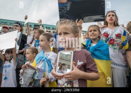 Berlin, Deutschland. August 2023. Am 24. August 2023 versammelten sich Ukrainer am Brandenburger Tor in Berlin, um den Unabhängigkeitstag der Ukraine zu begehen. Aber das war keine gewöhnliche Feier. Die Menge, ein Meer von Sonnenblumen, Fahnen, Fahnen und traditioneller ukrainischer Kleidung, kam mit einer Botschaft der Erinnerung und Belastbarkeit. In einer symbolischen Geste hielten die Teilnehmer Spiegel hoch, insgesamt 503, die jeweils das Gesicht eines Kindes widerspiegeln, das im russischen Krieg gegen die Ukraine verloren ging. Die Spiegel funkelten unter der untergehenden Sonne und dienten als eindringliche Erinnerung an die 503 ukrainischen Kinder, deren Leben abrupt und rücksichtslos war Stockfoto