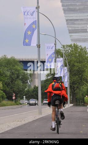 Bildnummer: 54144245  Datum: 14.06.2010  Copyright: imago/Xinhua (100614) -- LUXEMBOURG, June 14, 2010 (Xinhua) -- A cyclist passes the flags commemorating the 25th anniversary of the signing of Schengen Agreement in Schengen, Luxembourg, June 14, 2010. The agreement joined by 25 European countries was originally signed on June 14, 1985 by five European states including Belgium, France, then West Germany, Luxembourg and The Netherlands. (Xinhua/Wu Wei)(zl) (4)LUXEMBOURG-SCHENGEN AGREEMENT-25TH ANNICERSARY PUBLICATIONxNOTxINxCHN Reisen Gesellschaft kbdig xsk 2010 hoch premiumd xint o0 Jubiläum Stock Photo