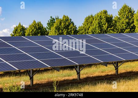 View along photovoltaic solar panels in an open space green energy generation plant, Germany Stock Photo