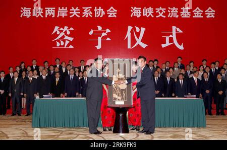 100629 -- CHONGQING, June 29, 2010 Xinhua -- Chiang Pin-kung L Front, chairman of the Taiwan-based Straits Exchange Foundation SEF, presents a gift to Chen Yunlin R, front, president of the mainland-based Association for Relations Across the Taiwan Straits ARATS, in Chongqing Municipality, southwest China, June 29, 2010. The two sides signed the long-awaited Economic Cooperation Framework Agreement ECFA and an agreement on intellectual property rights protection here Tuesday. Xinhua/Chen Jianli wjd 4CHINA-CHONGQING-MAINLAND-TAIWAN-AGREEMENT CN PUBLICATIONxNOTxINxCHN Stock Photo