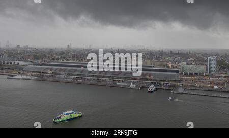 Amsterdamer Hauptbahnhof neben den Stadtkanal in Amsterdam, Niederlande, ein wichtiger Knotenpunkt für niederländische und internationale Züge. Stockfoto