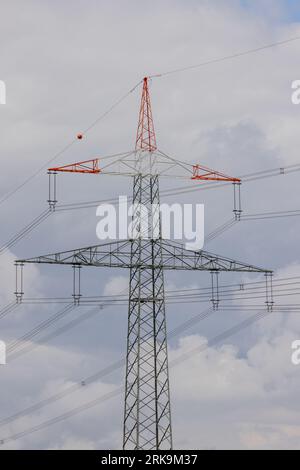Strommasten und Hochspannungsfreileitungen, die elektrische Energie über die Landschaft transportieren. Stockfoto
