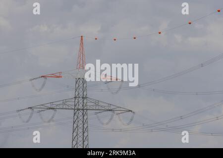 Strommasten und Hochspannungsfreileitungen, die elektrische Energie über die Landschaft transportieren. Stockfoto