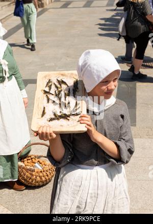 Teenager-Mädchen-Reenactor, gekleidet als mittelalterlicher Straßenverkäufer bei Targ Rybny oder Fischmarkt in der Altstadt von Danzig, Polen Stockfoto