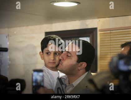 (100715) -- TEHRAN, July 15, 2010 (Xinhua) -- Iranian scholar Shahram Amiri (R) holds his son as he arrived in Tehran, July 15, 2010. Shaharm Amiri, 32, who arrived in Tehran early in the morning, told a news conference that he was kidnapped by the CIA and the abduction was part of the U.S. campaign to add political pressures to Iran. (Xinhua/Ahmad Halabisaz) (gj) (10)IRAN-SCHOLAR-SHAHRAM AMIRI-RETURN PUBLICATIONxNOTxINxCHN Stock Photo