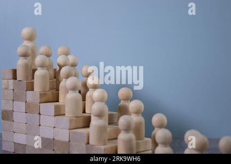 Ein schwacher Schuss einer Person, die die Holztreppe hinaufgeht, umgeben von vielen herabfallenden Herbstblättern. Stockfoto