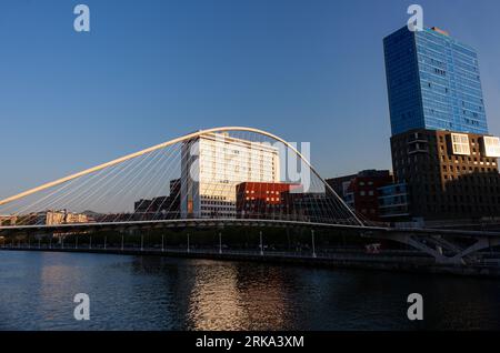 Bilbao, Spanien - 02. August 2022: Fluss Nervion und die Zubizuri-Brücke. Blick auf den Bilbao River bei Sonnenuntergang Stockfoto