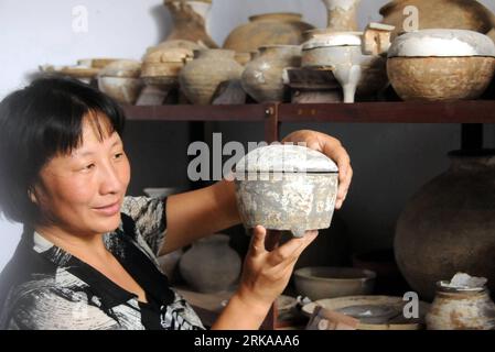 Bildnummer: 54294771  Datum: 12.08.2010  Copyright: imago/Xinhua (100813) -- SHIJIAZHUANG, Aug. 13, 2010 (Xinhua) -- A worker shows an entique pottery casket excavated from tombs dating back to the Han Dynasty (202 BC-220 AD) in Xingtai City, north China s Hebei Province. Archeologists have unearthed more than 260 antiques, such as spade-shaped coins, brass bells and pottery vessels, from 93 tombs of the Warring States (475-221 BC) period and the Han Dynasty in Xingtai s Zhangduo Village. The move was to protect the antiques from the potential effect brought by China s ongoing project of diver Stock Photo