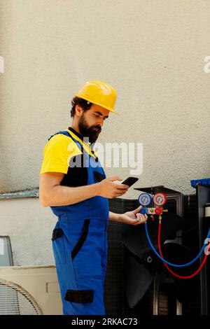 Efficient technician ordering new components for damaged air conditioner after finishing investigation. Experienced professional looking online for hvac system replacement parts, comissioned by client Stock Photo