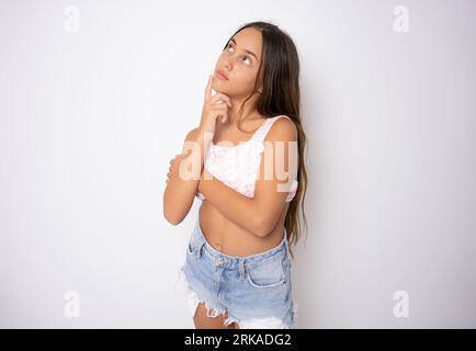 Zweifelhaft nachdenklich Teenager Kind Mädchen träumen, sich etwas vorstellen, Schaffung von Idee. Denkende nachdenkliche clevere Teenager-Mädchen. Stockfoto