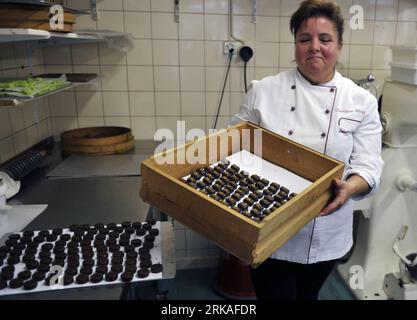 Bildnummer: 54343574 Datum: 24.08.2010 Copyright: imago/Xinhua Jannick Poncioni führt die von Hand hergestellten Schokoladen in Micheli Chocolate Shop in Genf, 24. August 2010. Der Micheli Schokoladenladen, 1964 von Pierre Poncioni und Liliane Poncioni, den Eltern von Dider und Jannick, gegründet, ist einer der berühmtesten Schokoladengeschäfte der Schweiz. Trotz der Dominanz industrieller Methoden besteht das Geschäft darauf, ihr traditionelles Rezept zu verwenden: Jedes Stück Schokolade wird ausschließlich von Hand hergestellt, mit einem Messer geschnitten und mit einer Gabel sorgfältig beschichtet. (Xinhua/Yu Yang) (wh) SCHWEIZ-GENF-HANDGEMACHTE SCHOKOLADE Stockfoto