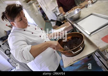 Bildnummer: 54343580  Datum: 24.08.2010  Copyright: imago/Xinhua Jannick Poncioni makes the chocolates by hand in Micheli Chocolate shop in Geneva, Aug. 24, 2010. The Micheli chocolate shop, founded in 1964 by Pierre Poncioni and Liliane Poncioni, parents of Dider and Jannick, is one of the most famous chocolate shops in Switzerland. Despite the domination of industrial methods, the shop insist using their traditional recipe: each piece of chocolate is made exclusively by hand, cut with a knife and carefully coated using a fork. (Xinhua/Yu Yang) (wh) SWITZERLAND-GENEVA-HANDMADE CHOCOLATE SHOP Stock Photo