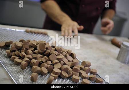 Bildnummer: 54343577  Datum: 24.08.2010  Copyright: imago/Xinhua Shop owner Didier Poncioni makes the chocolates by hand in Micheli Chocolate shop in Geneva, Aug. 24, 2010. The Micheli chocolate shop, founded in 1964 by Pierre Poncioni and Liliane Poncioni, parents of Dider and Jannick, is one of the most famous chocolate shops in Switzerland. Despite the domination of industrial methods, the shop insist using their traditional recipe: each piece of chocolate is made exclusively by hand, cut with a knife and carefully coated using a fork. (Xinhua/Yu Yang) (wh) SWITZERLAND-GENEVA-HANDMADE CHOCO Stock Photo