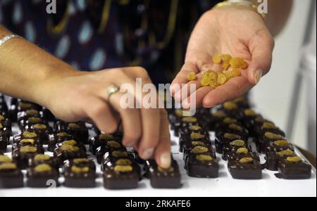 Bildnummer: 54343570  Datum: 24.08.2010  Copyright: imago/Xinhua A staff member makes the chocolates by hand in Micheli Chocolate shop in Geneva, Aug. 24, 2010. The Micheli chocolate shop, founded in 1964 by Pierre Poncioni and Liliane Poncioni, parents of Dider and Jannick, is one of the most famous chocolate shops in Switzerland. Despite the domination of industrial methods, the shop insist using their traditional recipe: each piece of chocolate is made exclusively by hand, cut with a knife and carefully coated using a fork. (Xinhua/Yu Yang) (wh) SWITZERLAND-GENEVA-HANDMADE CHOCOLATE SHOP PU Stock Photo