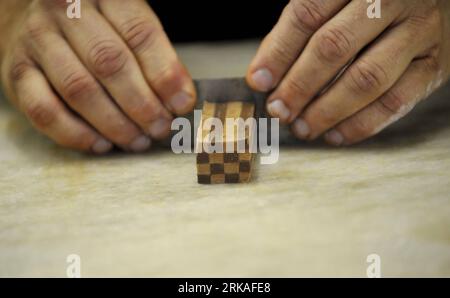 Bildnummer: 54343568  Datum: 24.08.2010  Copyright: imago/Xinhua Shop owner Didier Poncioni makes the chocolates by hand in Micheli Chocolate shop in Geneva, Aug. 24, 2010. The Micheli chocolate shop, founded in 1964 by Pierre Poncioni and Liliane Poncioni, parents of Dider and Jannick, is one of the most famous chocolate shops in Switzerland. Despite the domination of industrial methods, the shop insist using their traditional recipe: each piece of chocolate is made exclusively by hand, cut with a knife and carefully coated using a fork. (Xinhua/Yu Yang) (wh) SWITZERLAND-GENEVA-HANDMADE CHOCO Stock Photo