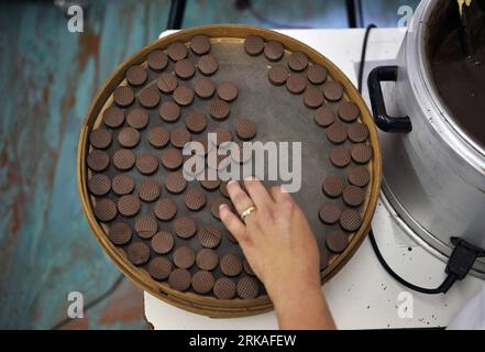 Bildnummer: 54343584  Datum: 24.08.2010  Copyright: imago/Xinhua A staff member makes the chocolates by hand in Micheli Chocolate shop in Geneva, Aug. 24, 2010. The Micheli chocolate shop, founded in 1964 by Pierre Poncioni and Liliane Poncioni, parents of Dider and Jannick, is one of the most famous chocolate shops in Switzerland. Despite the domination of industrial methods, the shop insist using their traditional recipe: each piece of chocolate is made exclusively by hand, cut with a knife and carefully coated using a fork. (Xinhua/Yu Yang) (wh) SWITZERLAND-GENEVA-HANDMADE CHOCOLATE SHOP PU Stock Photo