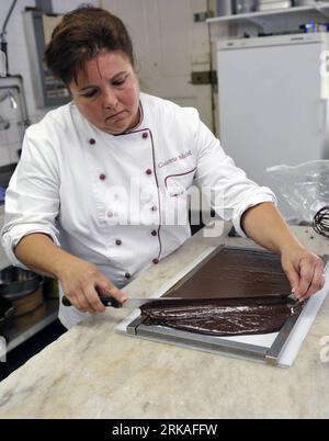 Bildnummer: 54343581 Datum: 24.08.2010 Copyright: imago/Xinhua Jannick Poncioni stellt die Schokoladen von Hand in Micheli Chocolate Shop in Genf, 24. August 2010 her. Der Micheli Schokoladenladen, 1964 von Pierre Poncioni und Liliane Poncioni, den Eltern von Dider und Jannick, gegründet, ist einer der berühmtesten Schokoladengeschäfte der Schweiz. Trotz der Dominanz industrieller Methoden besteht das Geschäft darauf, ihr traditionelles Rezept zu verwenden: Jedes Stück Schokolade wird ausschließlich von Hand hergestellt, mit einem Messer geschnitten und mit einer Gabel sorgfältig beschichtet. (Xinhua/Yu Yang) (wh) SCHWEIZ-GENF-HANDGEMACHTE SCHOKOLADENLADEN Stockfoto