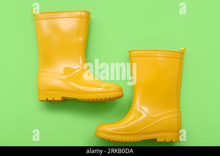 Yellow gumboots on green background Stock Photo