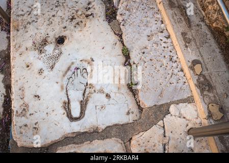 Alte Fußabdrücke, weibliche Figur und Herzform auf dem Marmorboden. Zeichen zeigen die Richtung des Hauses der Liebe. Ruinen der antiken Stadt Ephesus. Auswahl Stockfoto