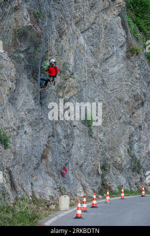 Dossena Italy 24. August 2023: Kletterer platzieren Sicherheitsnetze, um herabfallende Felsen zu vermeiden Stockfoto