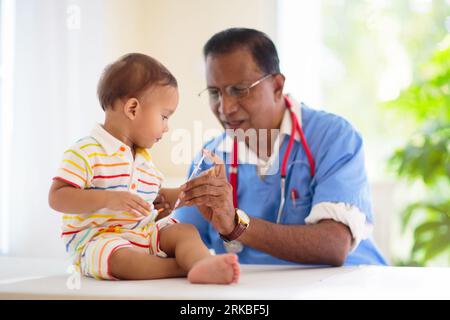 Kinderarzt untersucht Baby. Asiatischer Junge in der Gesundheitsklinik für Test und Screening. Säuglingsimpfung. Kinderbehandlung und Check-up. Stockfoto