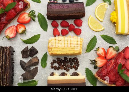 Flache Liegezusammensetzung mit verschiedenen leckeren Kuchen auf hellgrauem Tisch Stockfoto