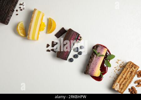 Flache Liegezusammensetzung mit verschiedenen leckeren Kuchen auf einem hellen Tisch Stockfoto