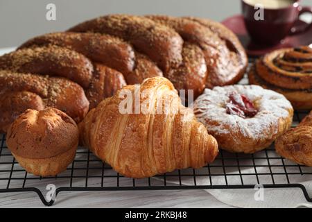 Verschiedene leckere, frisch gebackene Backwaren auf weißem Holztisch, Nahaufnahme Stockfoto